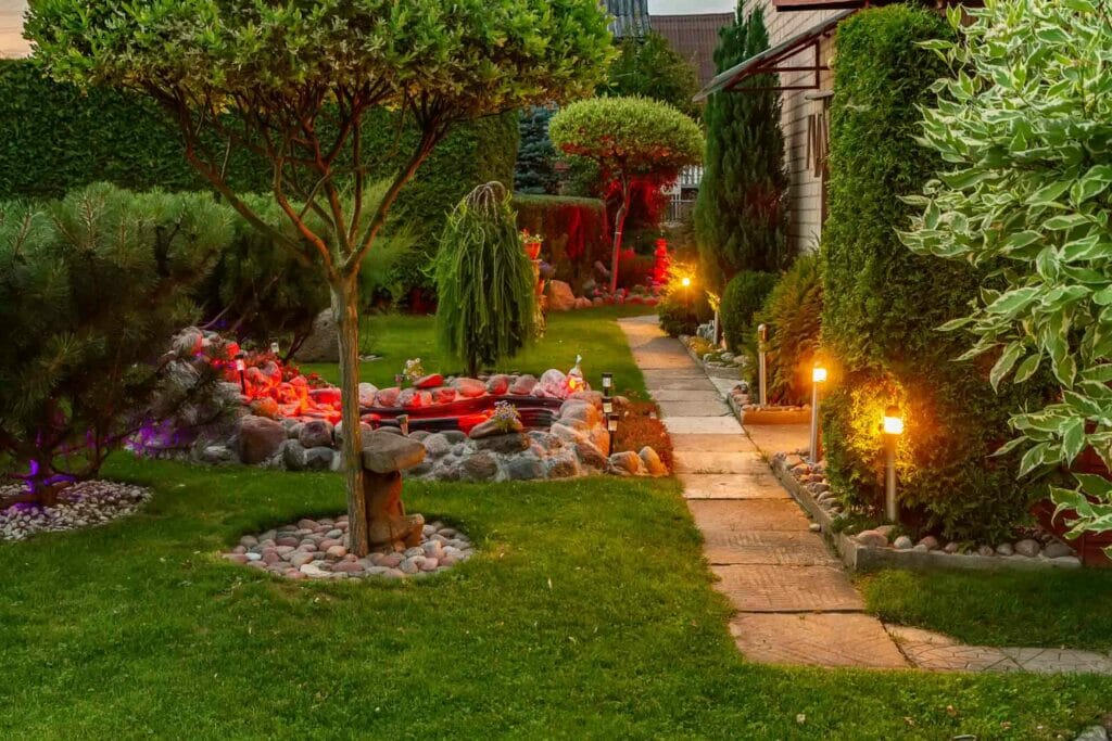 This backyard oasis provides the perfect escape from the hustle and bustle of everyday life. With its lush green landscaping and beautiful light fixtures, it's easy to relax and forget about your troubles. Take a few minutes to yourself and enjoy the peace and quiet this backyard has to offer.