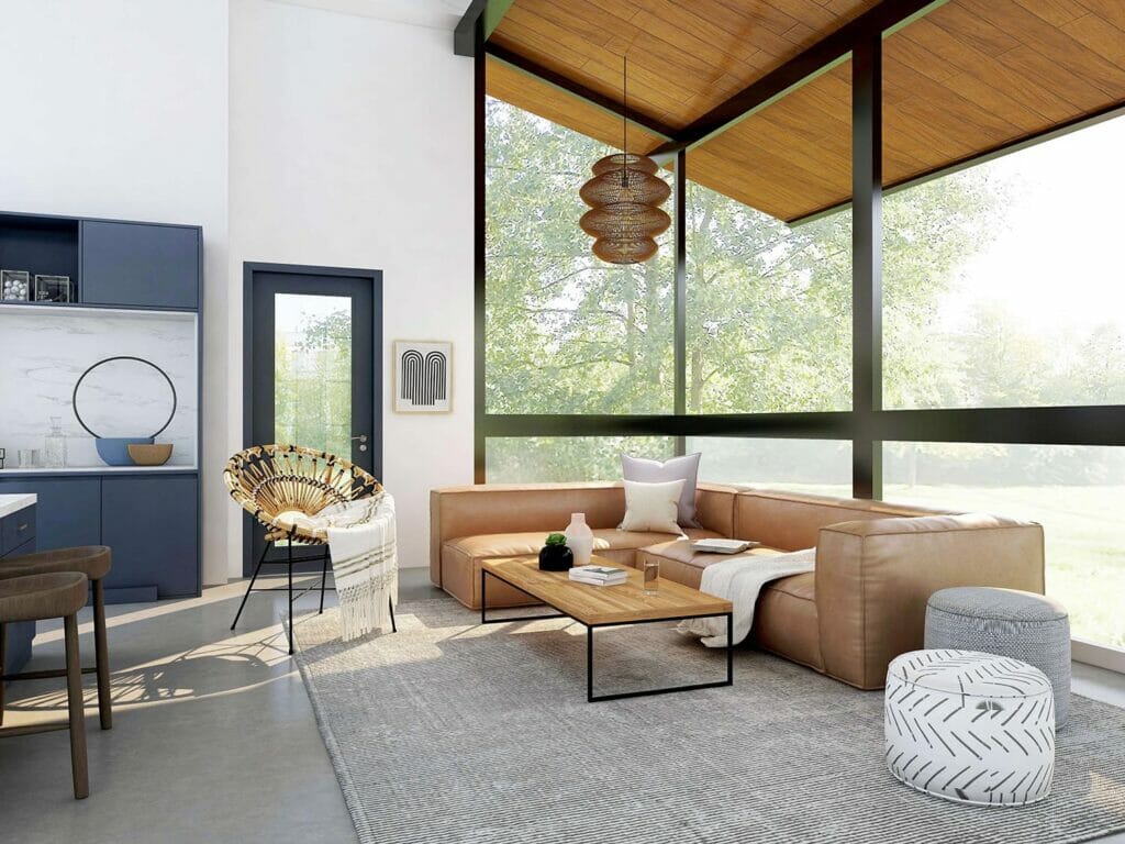 A modern home’s living room with floor-to-ceiling windows and a leather couch.